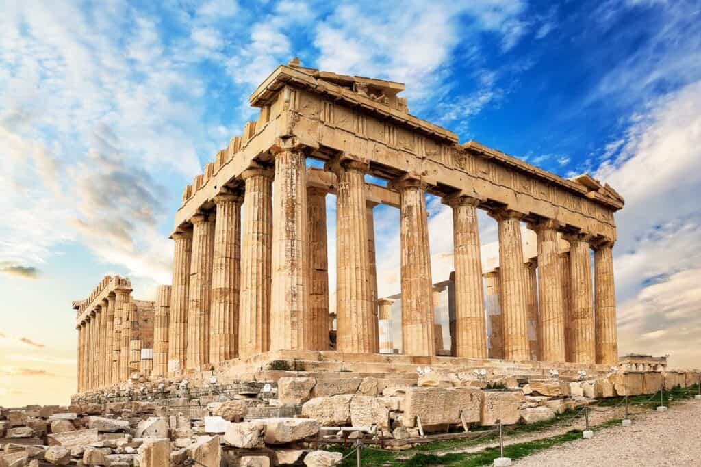 The Parthenon, a symbol of ancient Greece, stands with its Doric columns and remaining entablature against a dramatic backdrop of a cloudy sky.