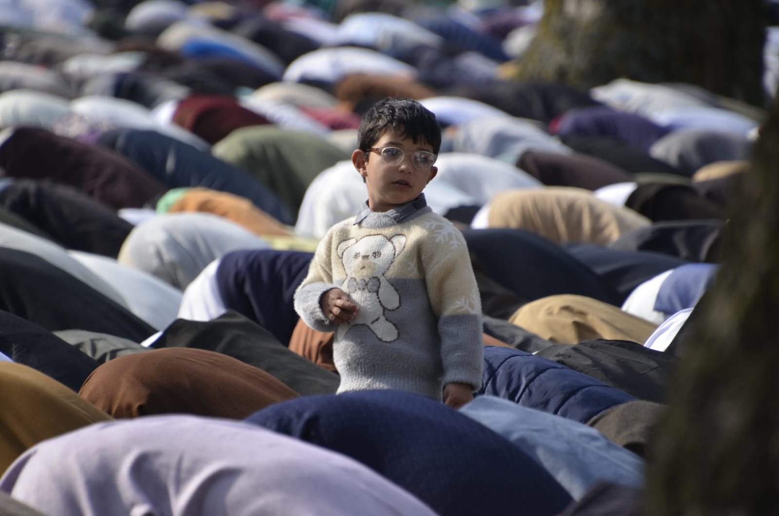 A child stands amidst the ongoing Eid-ul-Fitr prayers at an Eid Gah in Kashmir. (KL-image Majid Maqbool)